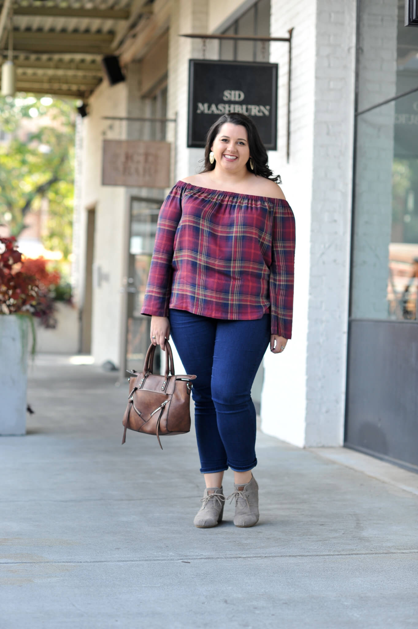 Emily Bastedo from the curvy style blog, Something Gold, Something Blue shares a great fall transition outfit with this adorable off the shoulder plaid top from Anthropolgie, a pair of skinny jeans, Toms wedges and a gorgeous bag from Pinkstix.
