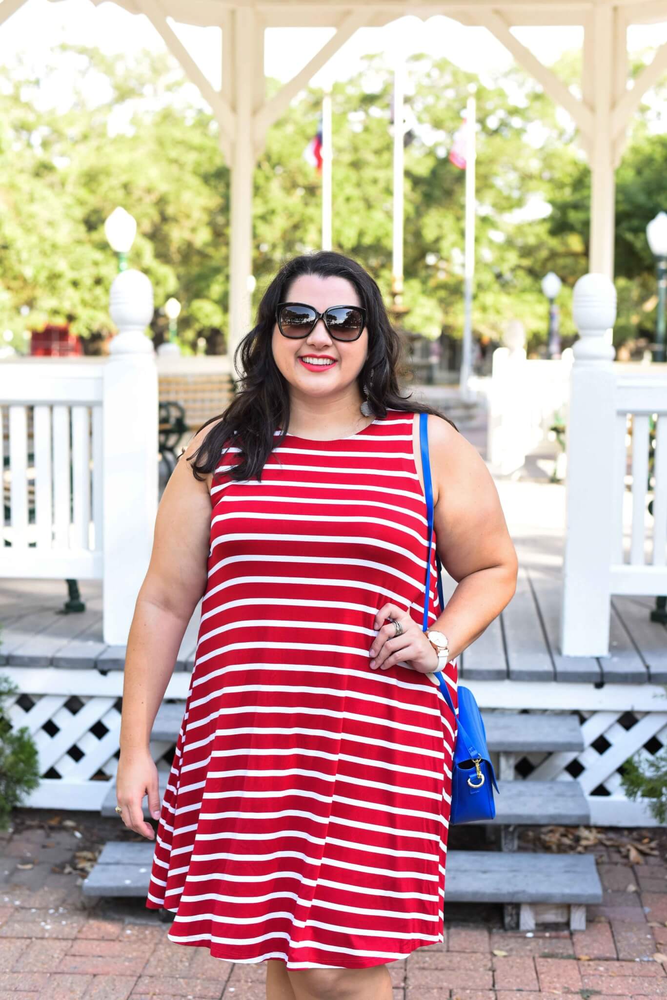 Looking for the perfect 4th of July outfit? Emily Bastedo from the curvy style blog, Something Gold, Something Blue is sharing a light and breezy red and white striped dress paired a blue accent bag. Summer style, Sneakers with dresses, Curvy style